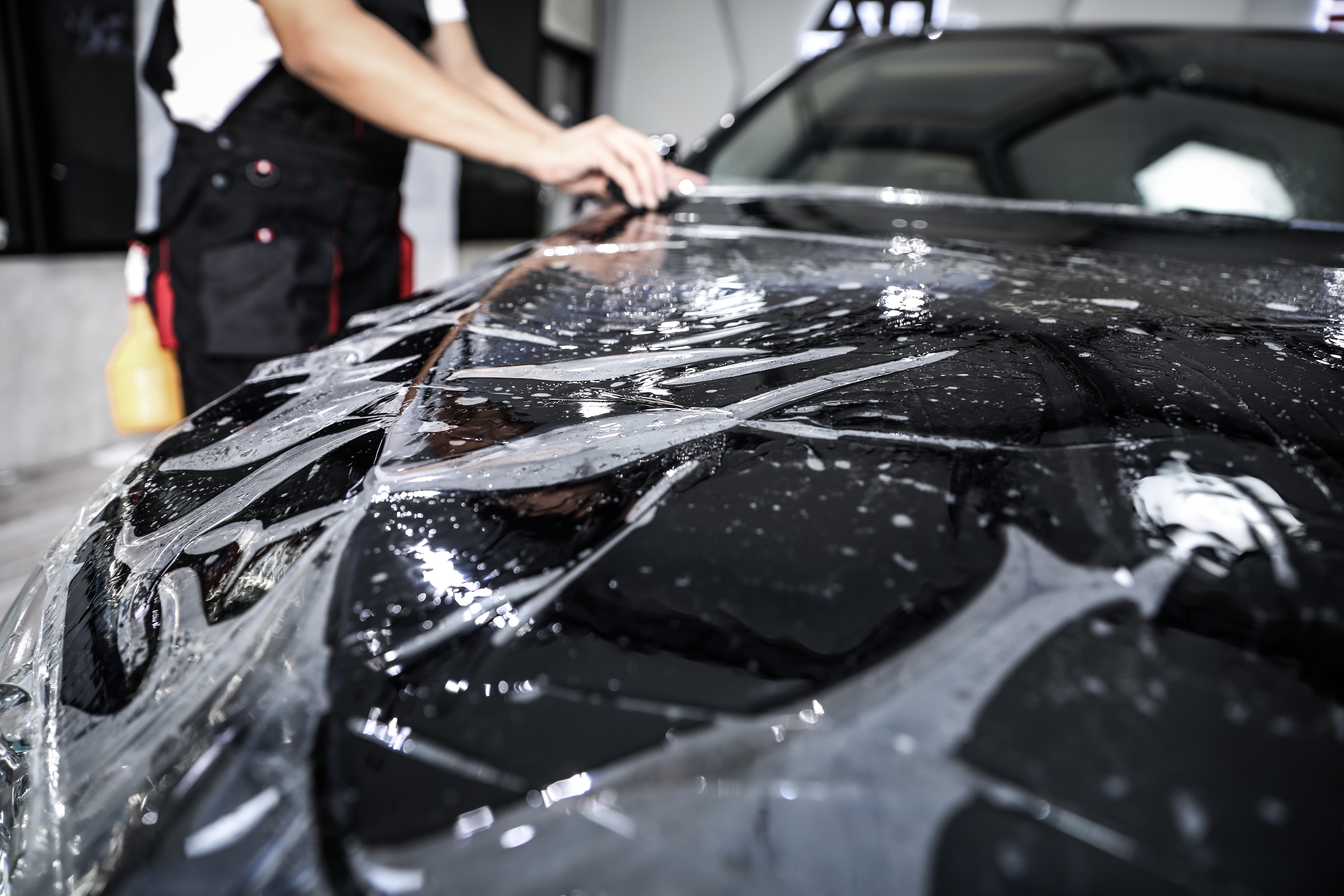 A car receiving a layer of paint protection film from a Dapper Pros professional.
