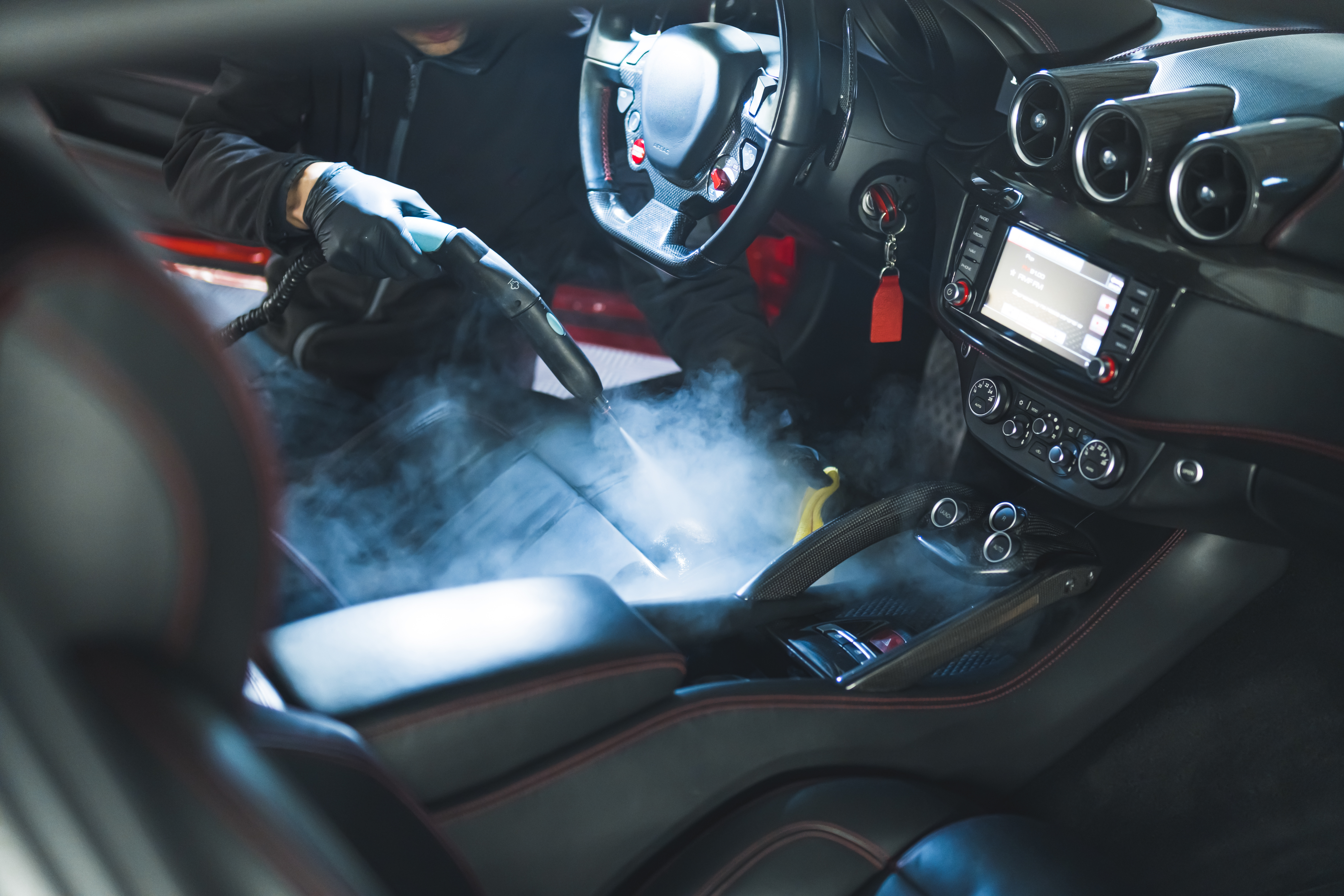 A Dapper Pros service professional providing an interior steam car detailing.