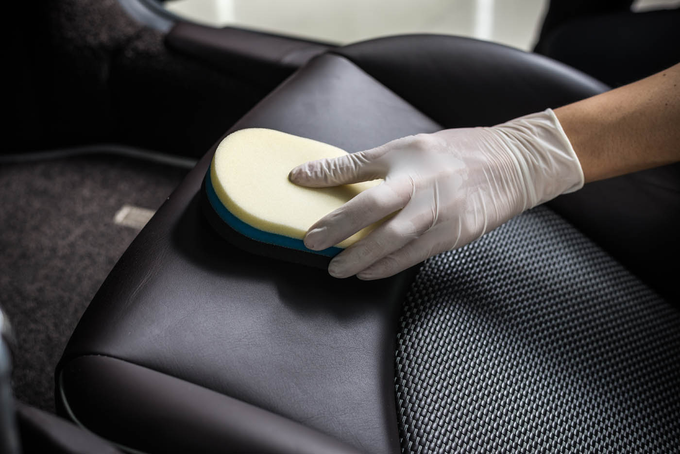 A Dapper Pros service professional performing a leather seat cleaning.