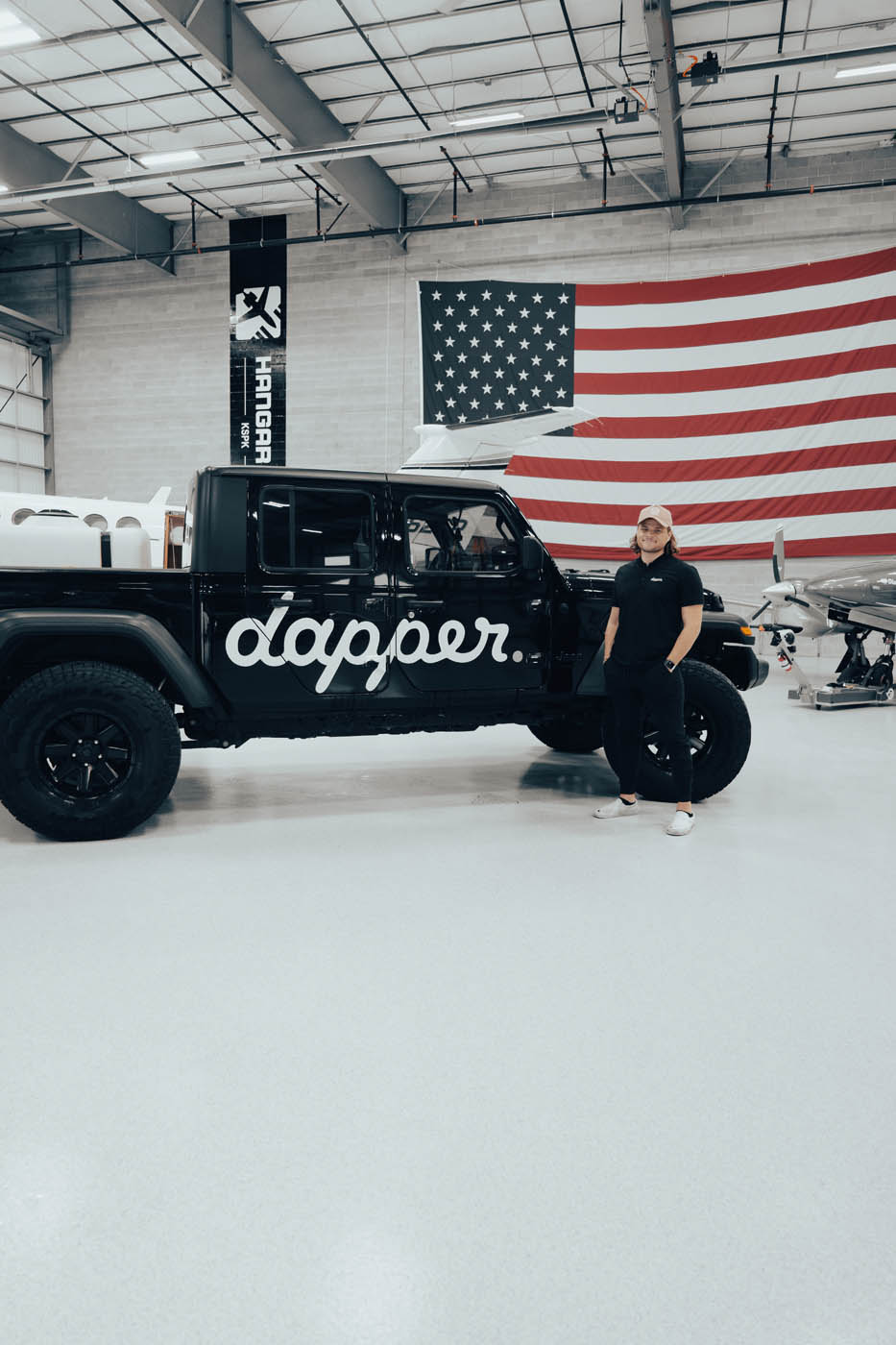 Dapper Pros owner, Henry Briggs, standing in front of their Dapper jeep truck.