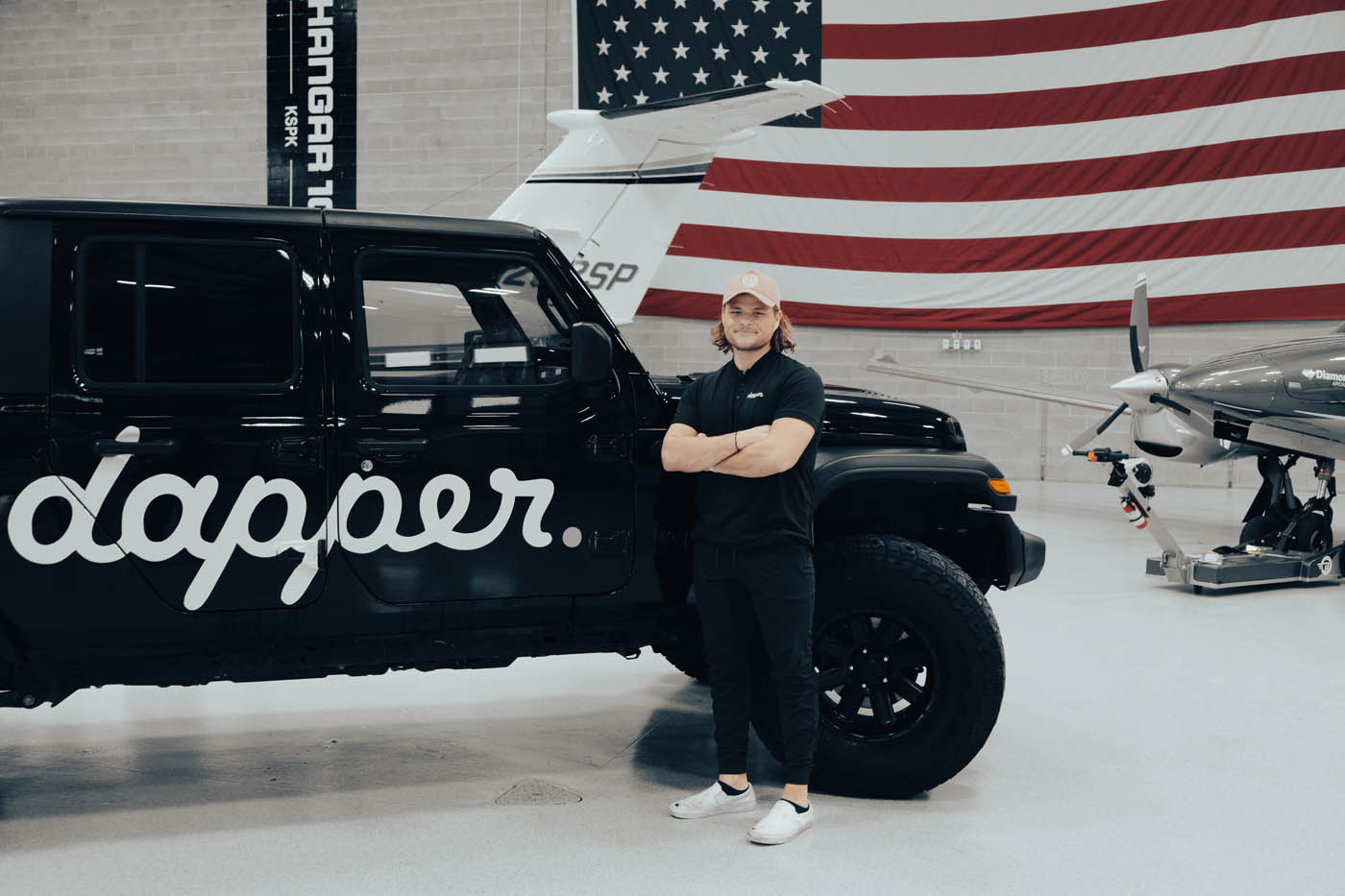 Dapper Pros Portland owner, Henry Briggs, standing in front of the Dapper jeep truck.